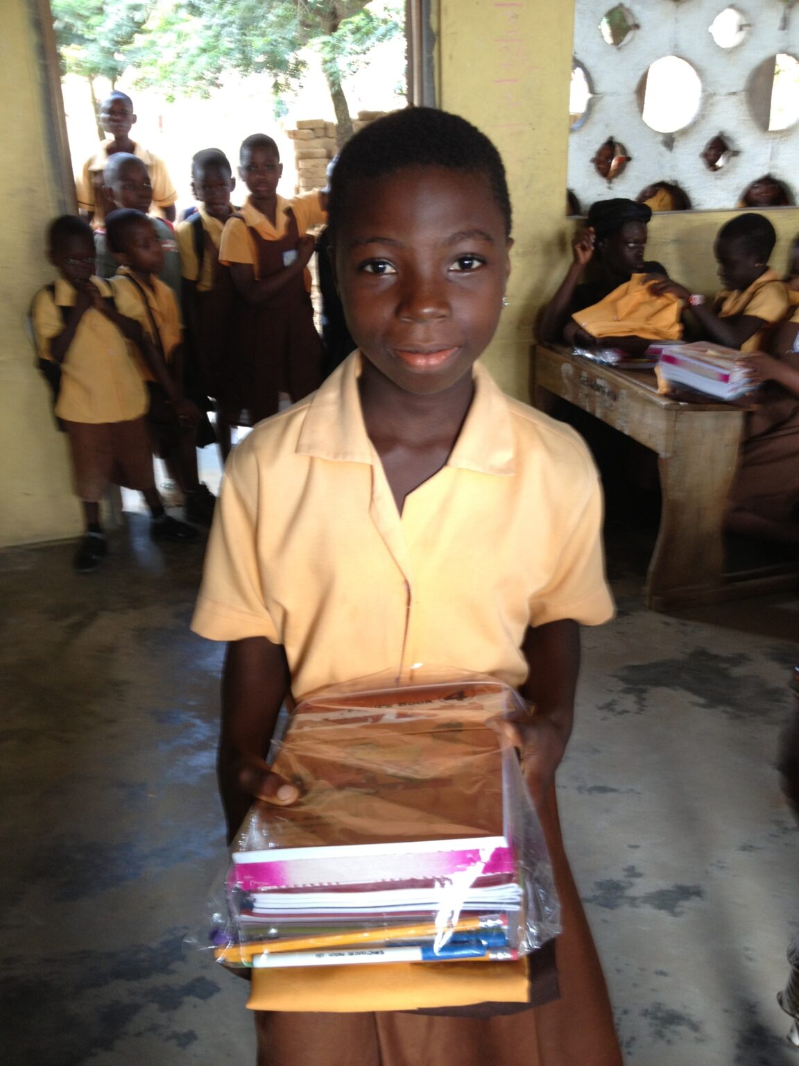 A boy in yellow shirt holding a book.