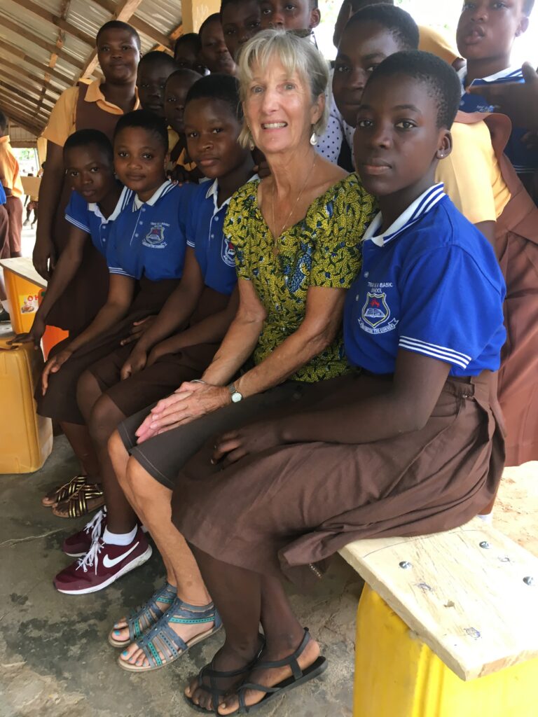 A woman sitting on top of a bench next to some kids.