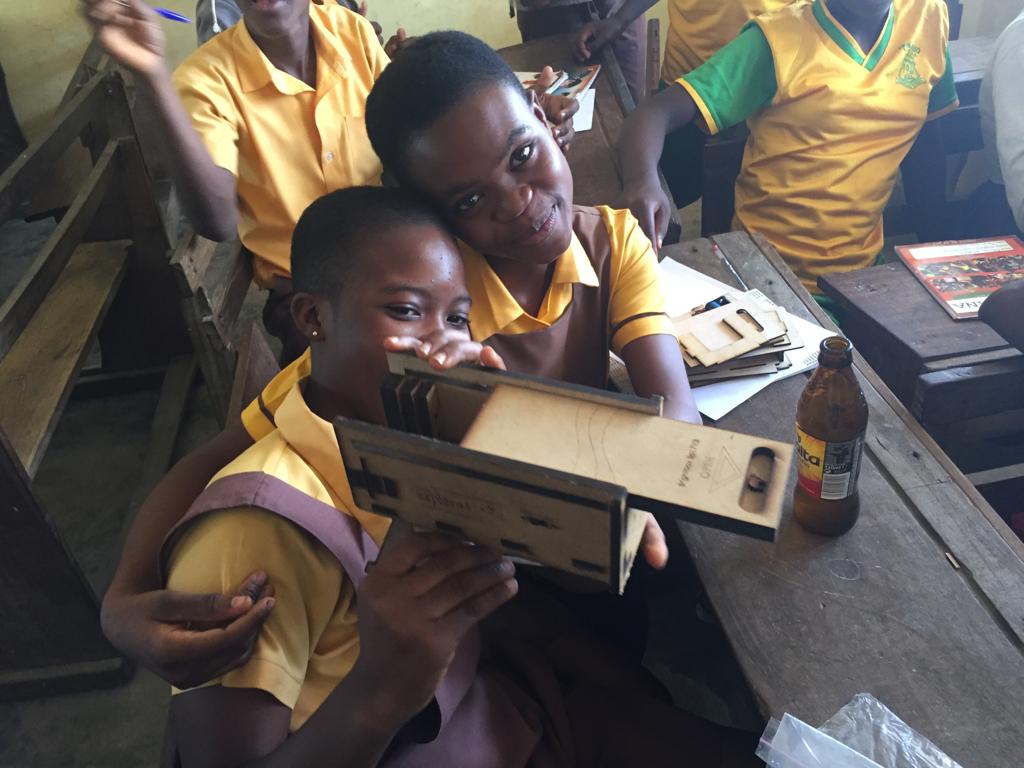 Two boys in yellow shirts holding a box.